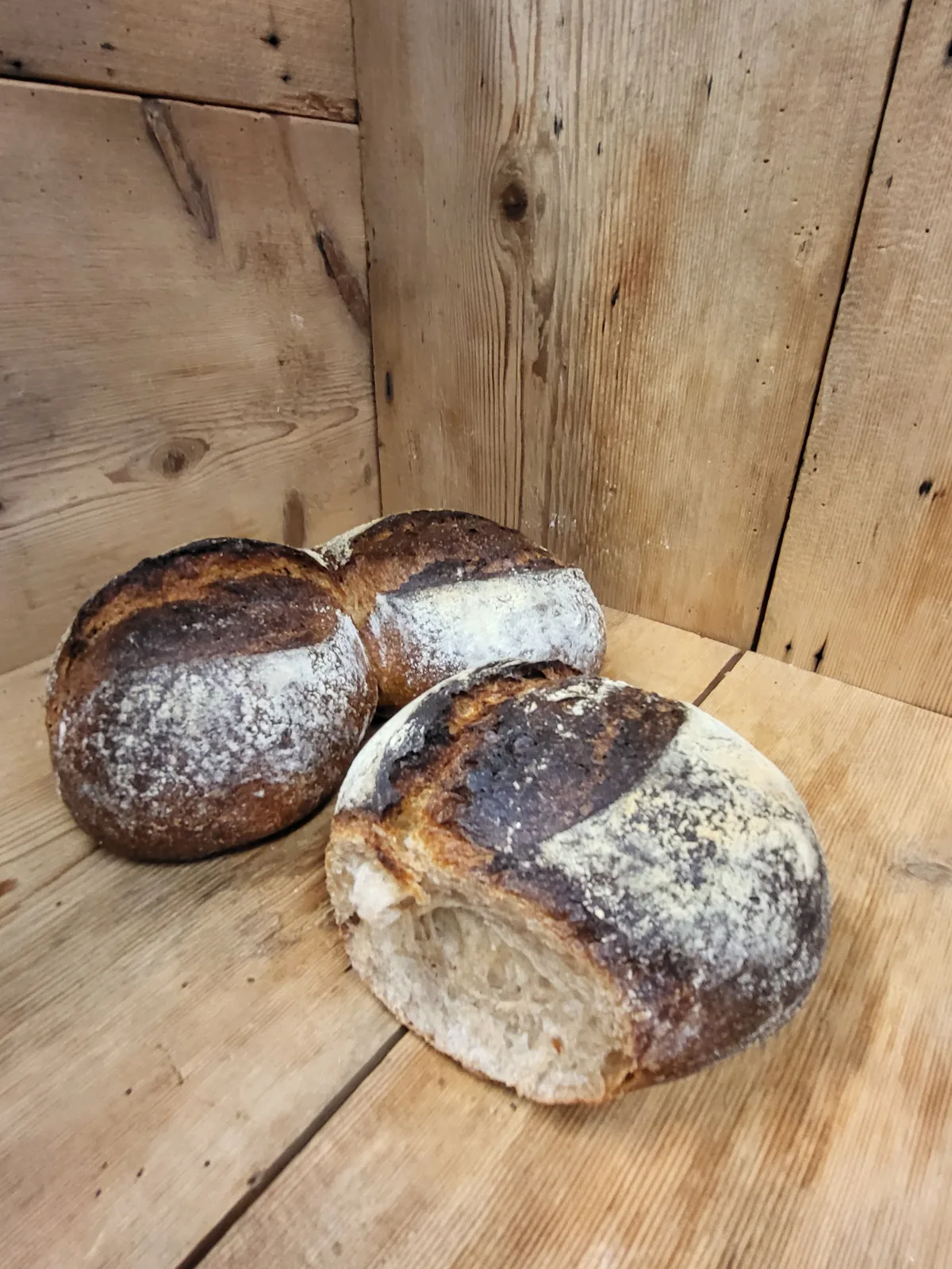 Drei Brötchen liegen auf Holz.